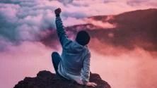 Person on top of a mountain, arm raise